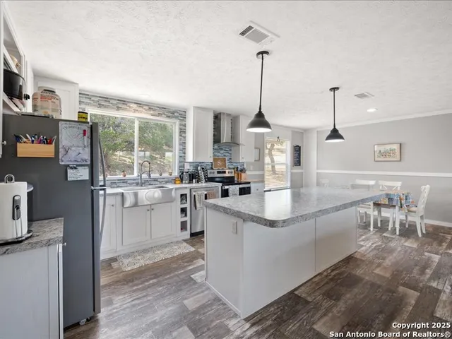 a kitchen with stainless steel appliances granite countertop sink stove and cabinets
