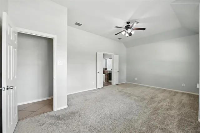 a view of an empty room with a chandelier fan