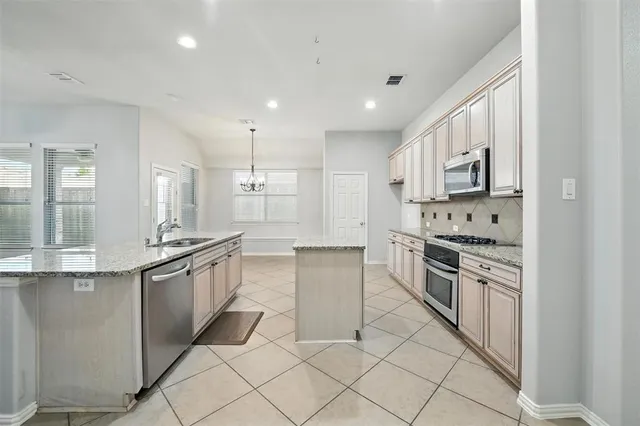 a kitchen with stainless steel appliances granite countertop a sink and cabinets