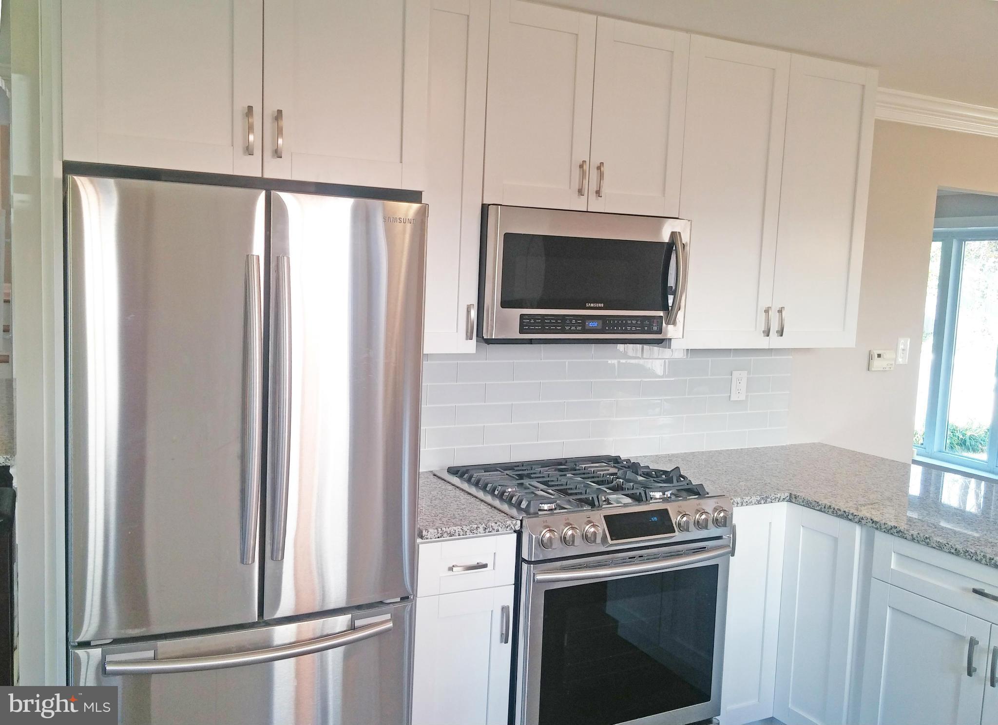 13310 Tamarack Road Silver Spring, MD 20904 - Photo 3 of 30 a kitchen with stainless steel appliances wooden cabinets and a stove top oven