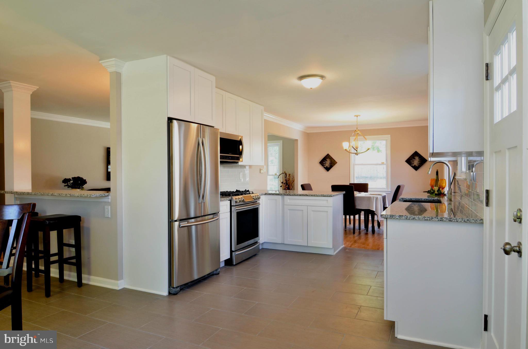13310 Tamarack Road Silver Spring, MD 20904 - Photo 4 of 30 a kitchen with refrigerator and chairs