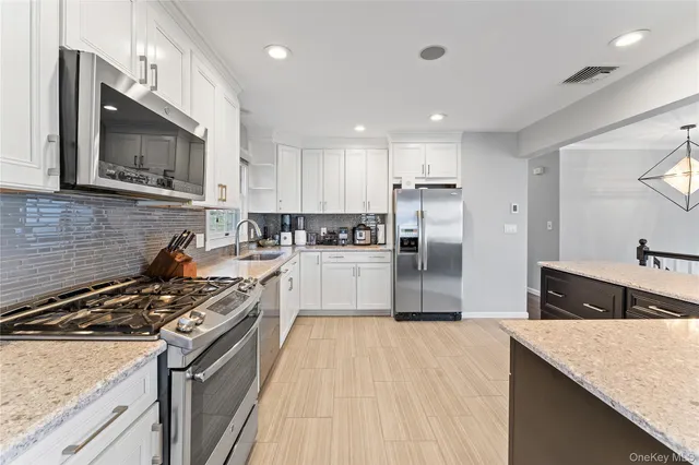 a kitchen with stainless steel appliances kitchen island wooden cabinets and a wooden floor