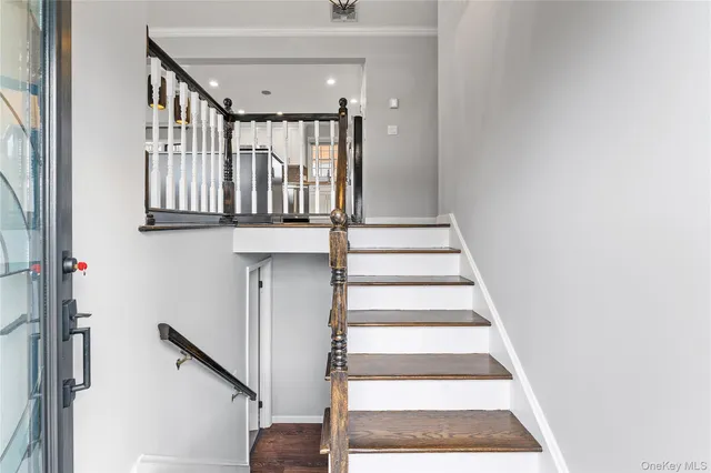 a view of staircase with lots of frames on wall and windows