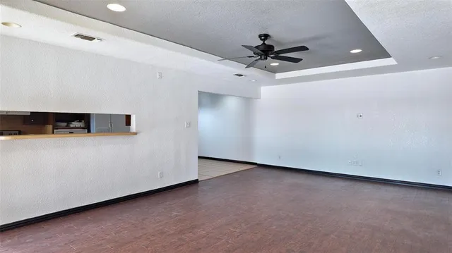 a view of a livingroom with a ceiling fan and wooden floor