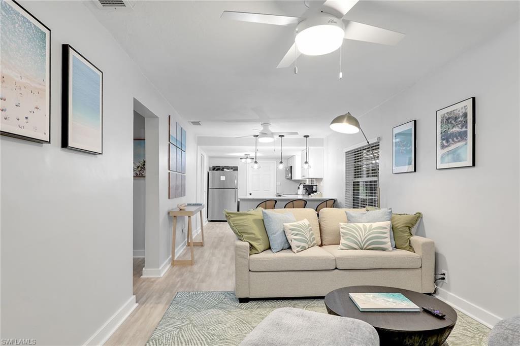 2780 Weeks Avenue Naples, FL 34112 - Photo 2 of 34 a living room with furniture and a chandelier