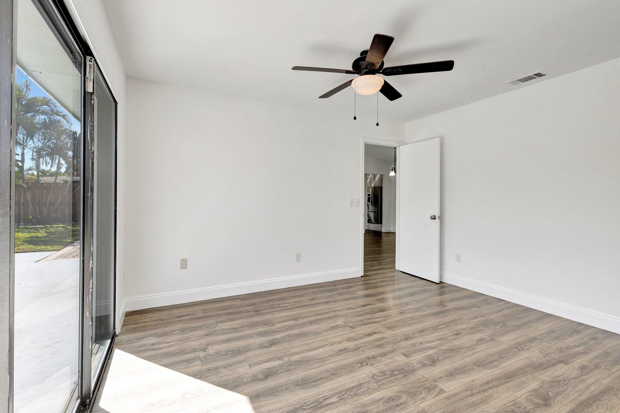 9404 Longmeadow Circle Boynton Beach, FL 33436 - Photo 18 of 28 a view of empty room with wooden floor and fan