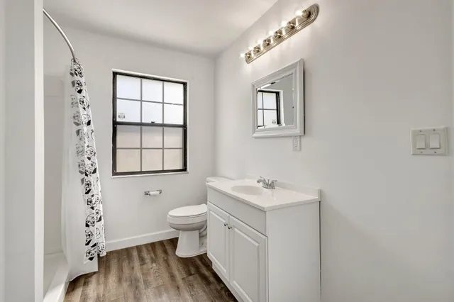 a bathroom with a sink a toilet and shower