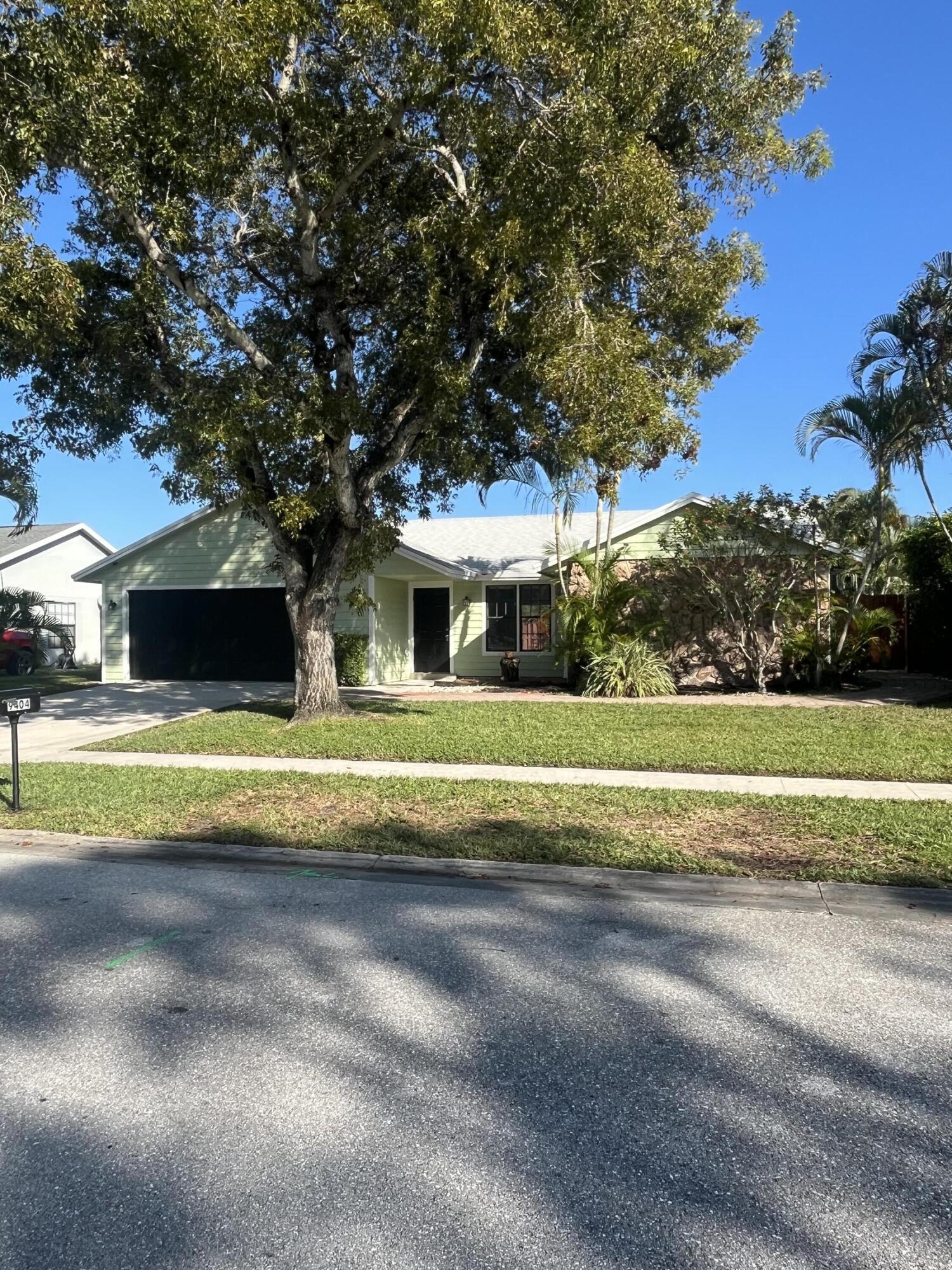 9404 Longmeadow Circle Boynton Beach, FL 33436 - Photo 2 of 28 a front view of a house with a yard