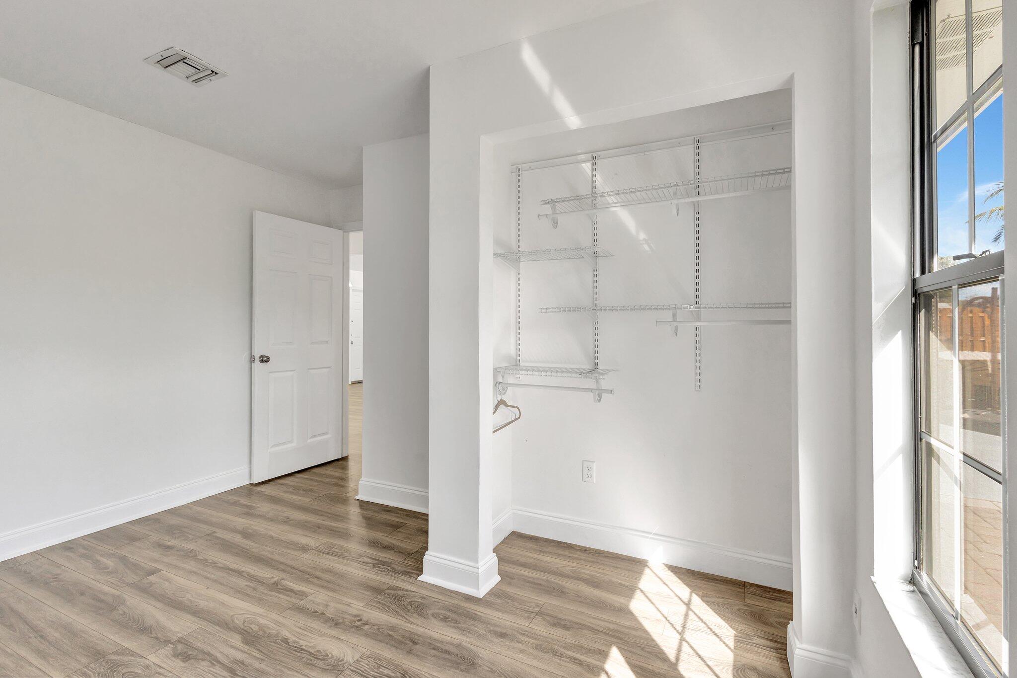 9404 Longmeadow Circle Boynton Beach, FL 33436 - Photo 23 of 28 a view of an empty room with wooden floor and a window