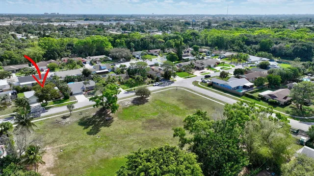 an aerial view of residential houses with outdoor space and trees