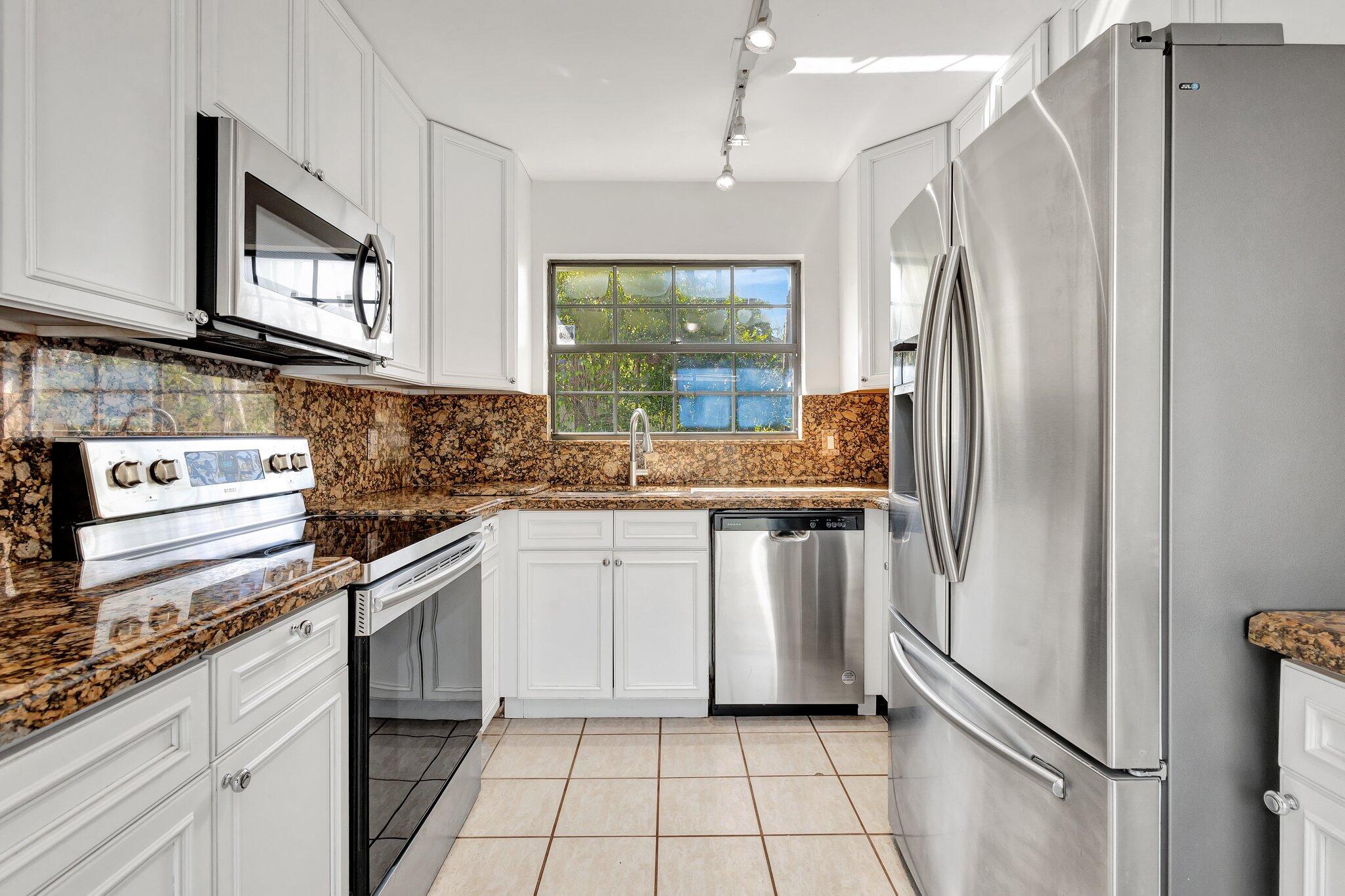 9404 Longmeadow Circle Boynton Beach, FL 33436 - Photo 6 of 28 a kitchen with stainless steel appliances granite countertop a refrigerator and a sink