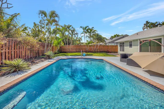 a view of a house with swimming pool and sitting area