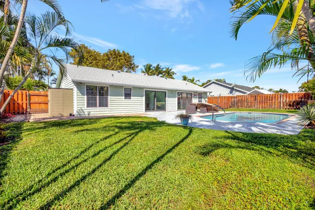 a view of a house with pool and a yard