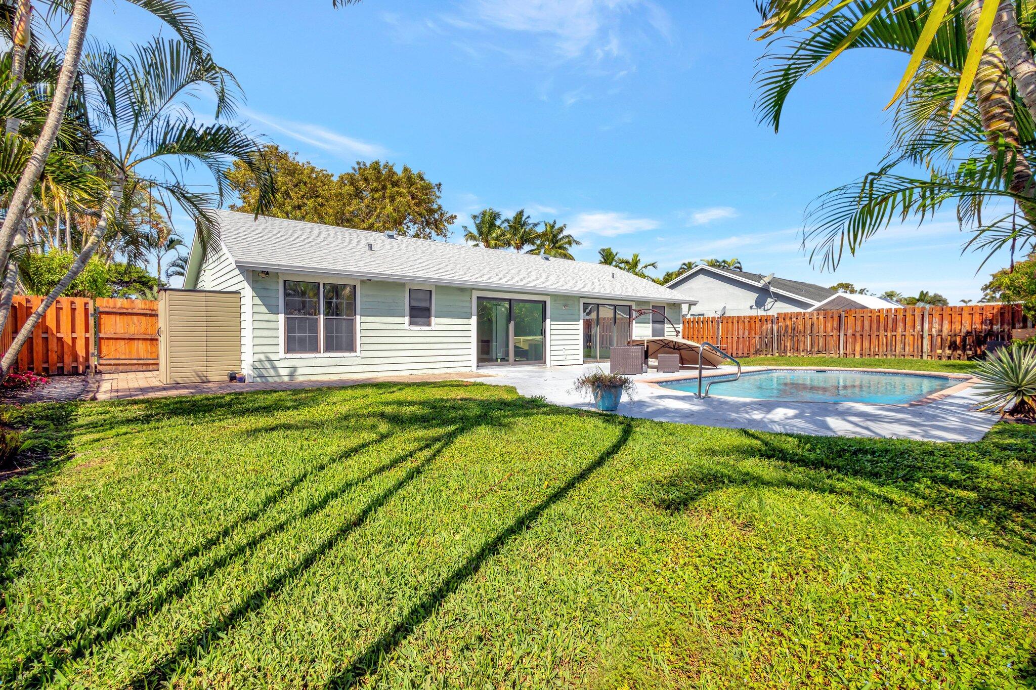 9404 Longmeadow Circle Boynton Beach, FL 33436 - Photo 9 of 28 a view of a house with pool and a yard