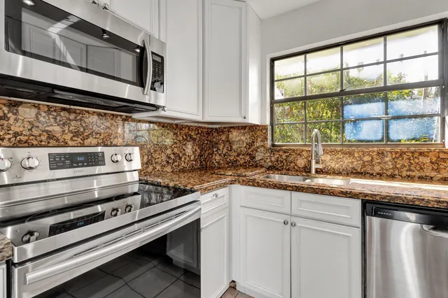 a kitchen with stainless steel appliances granite countertop a sink and a stove