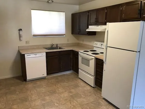 a kitchen with a stove a refrigerator and a sink