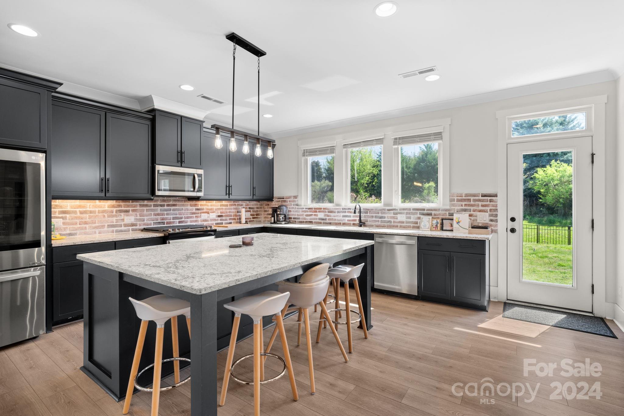 815 Bluff Loop Road Rock Hill, SC 29730 - Photo 10 of 35 a kitchen with kitchen island granite countertop wooden floor cabinets and appliances