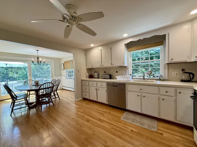 a kitchen with stainless steel appliances granite countertop a dining table chairs refrigerator sink and cabinets
