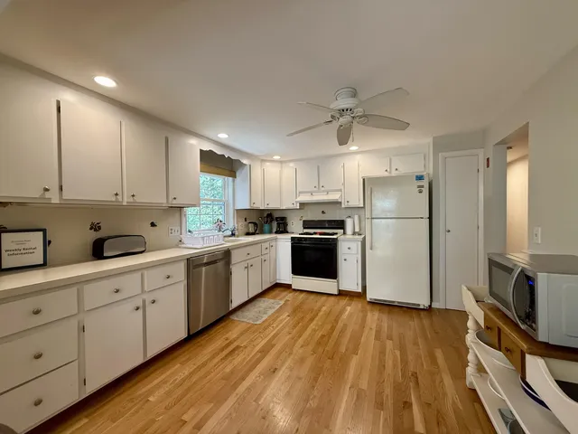 a kitchen with white cabinets and stainless steel appliances