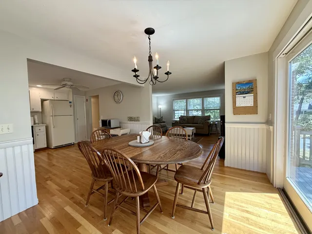 a view of a a dining room with furniture window and wooden floor