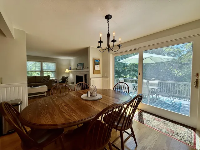 a dining room with furniture a chandelier and wooden floor