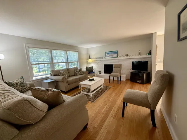a living room with furniture large window and a fireplace