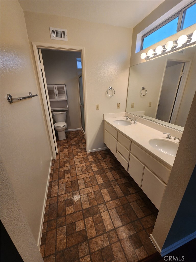 29806 Coral Tree Court Menifee, CA 92584 - Photo 13 of 29 a bathroom with a sink a toilet and a mirror