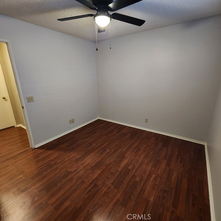 29806 Coral Tree Court Menifee, CA 92584 - Photo 20 of 29 an empty room with wooden floor and fan