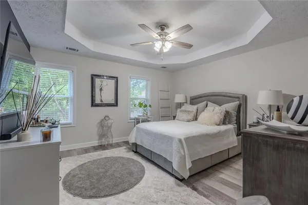 a bedroom with a large bed and a chandelier