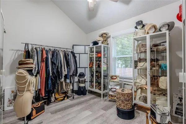 a view of walk in closet with clothes and shoes