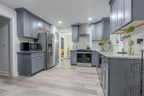 a kitchen with granite countertop stainless steel appliances and wooden cabinets