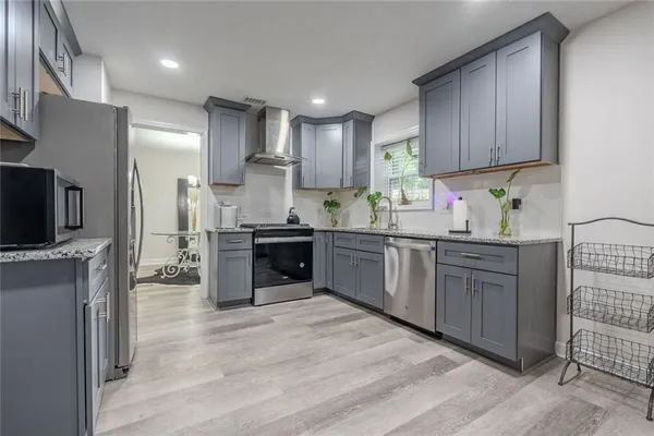 a kitchen with stainless steel appliances kitchen island granite countertop a stove sink and cabinets