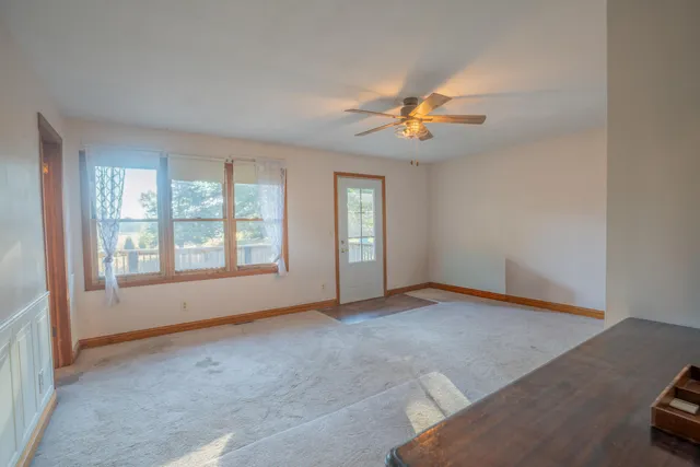 a view of a livingroom with a ceiling fan and window