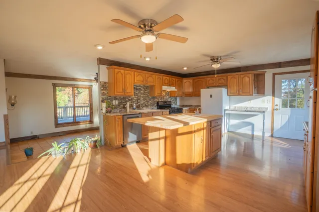 a large kitchen with stainless steel appliances granite countertop a lot of counter space and wooden floors