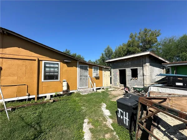 a view of a chair and table in backyard of the house