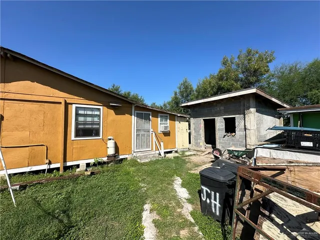 a view of a chair and table in backyard of the house