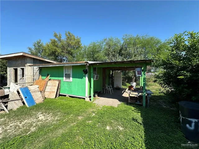 a view of a backyard with table and chairs under an umbrella