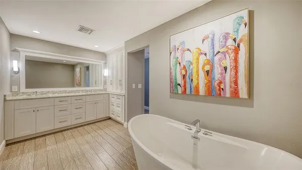 a bathroom with a granite countertop sink a mirror and a bathtub