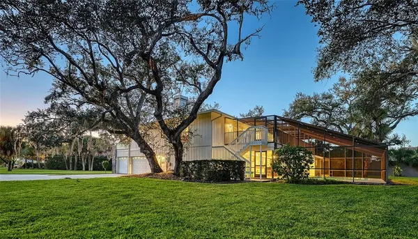 a view of a house with a big yard and large trees