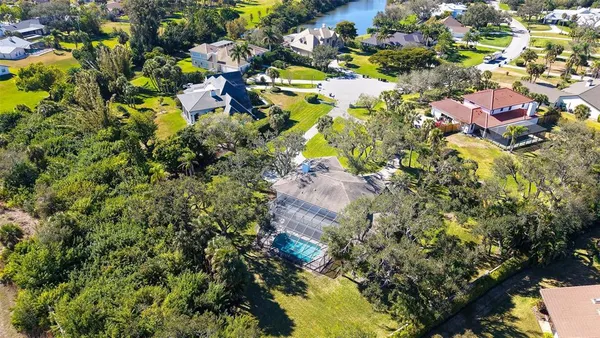 an aerial view of a house with a yard and large trees