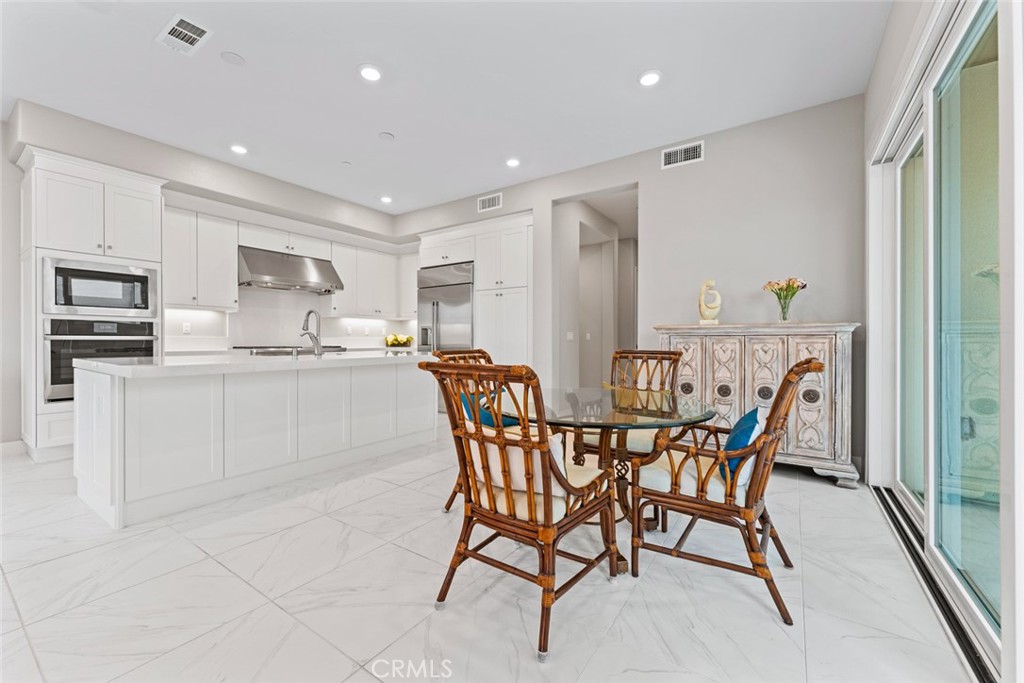 168 Perspective Irvine, CA 92618 - Photo 13 of 49 a dining area with stainless steel appliances kitchen island granite countertop a sink a stove a dining table and chairs