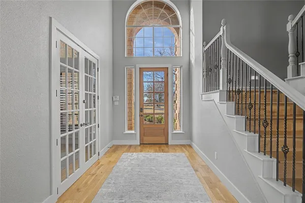 a view of a big room with wooden floor a ceiling fan and windows