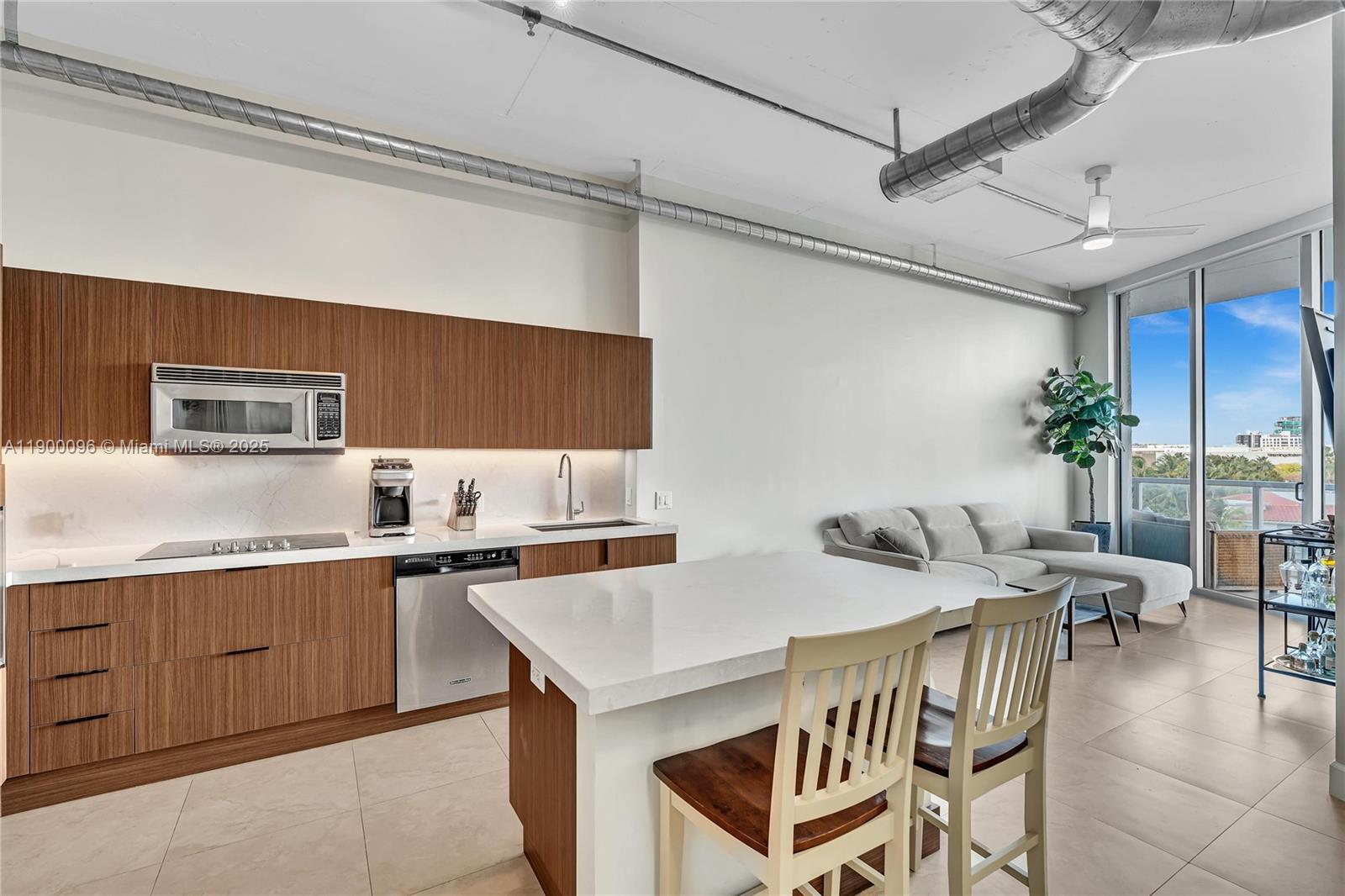 3029 Northeast 188th Street, Unit 503 Aventura, FL 33180 - Photo 11 of 60 a kitchen with a table chairs and a refrigerator