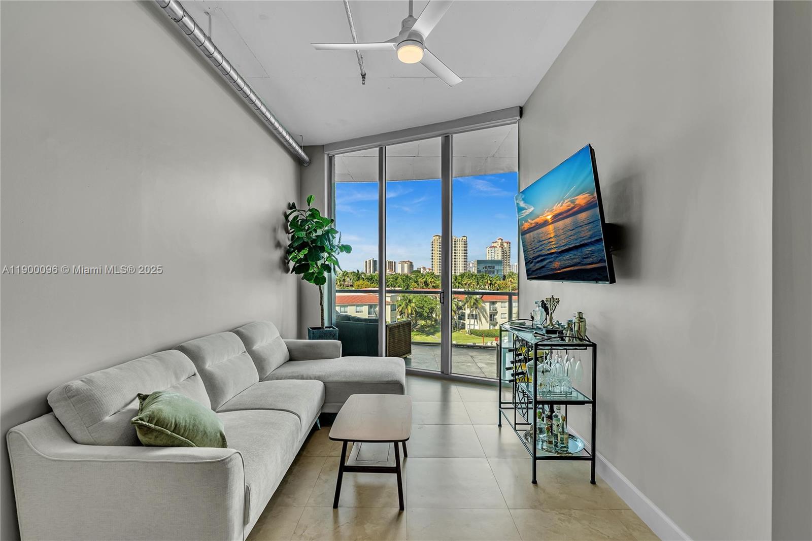3029 Northeast 188th Street, Unit 503 Aventura, FL 33180 - Photo 13 of 60 a living room with furniture a ceiling fan and a flat screen tv