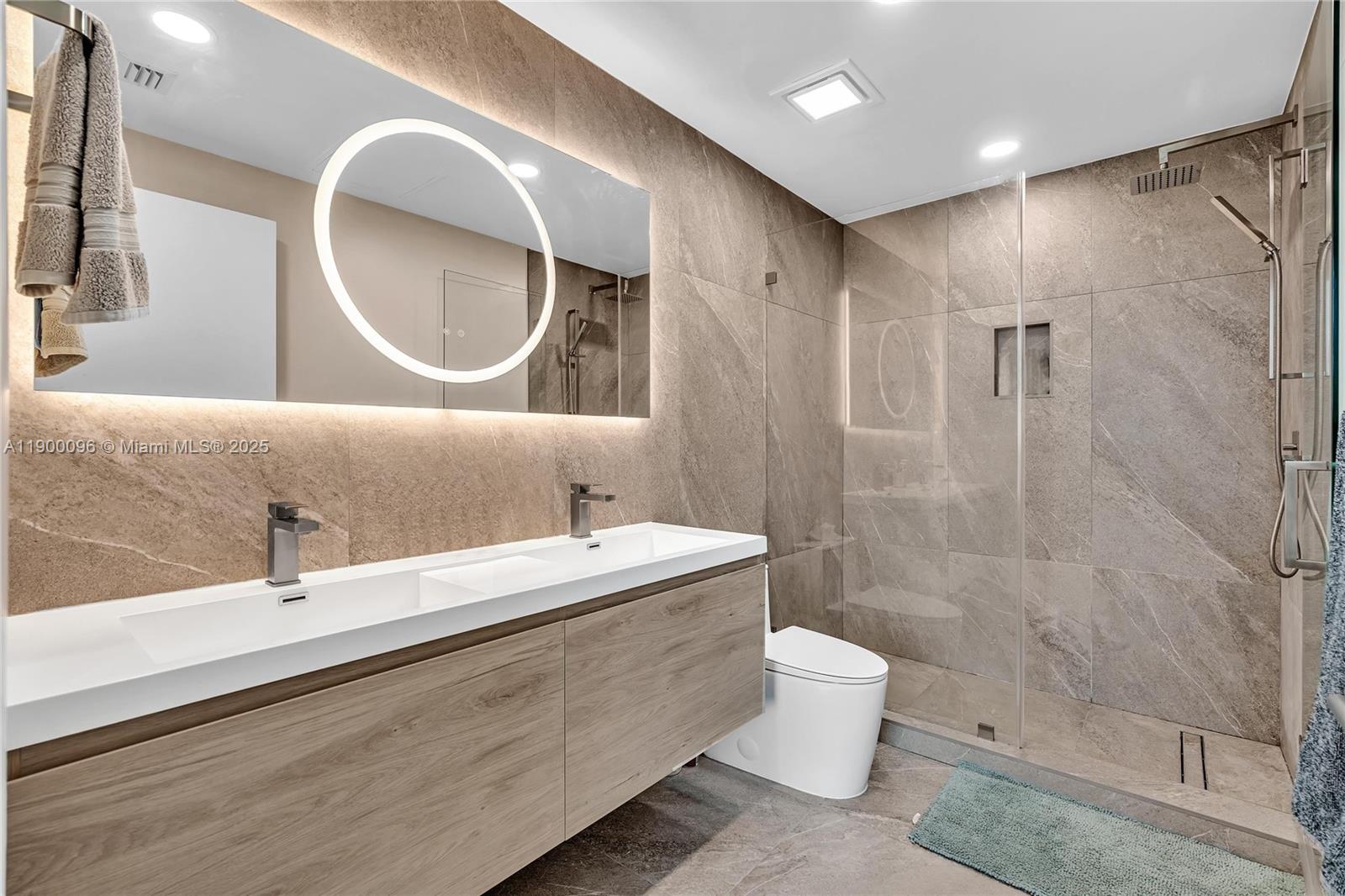 3029 Northeast 188th Street, Unit 503 Aventura, FL 33180 - Photo 32 of 60 a bathroom with a double vanity sink toilet mirror and shower