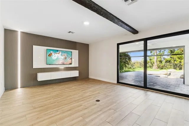 a dining room with wooden floor a chandelier a wooden table and chairs