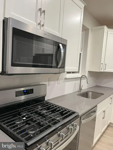 a stove top oven sitting inside of a kitchen