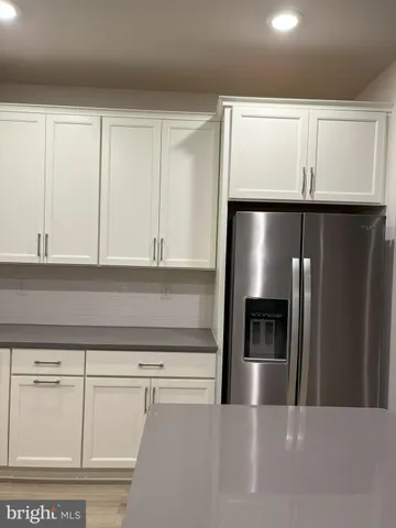 a kitchen with granite countertop white cabinets and stainless steel appliances