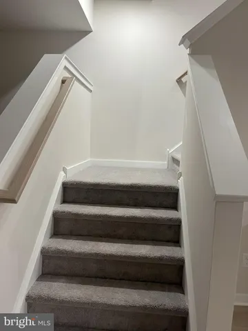 a view of staircase with white walls and a window
