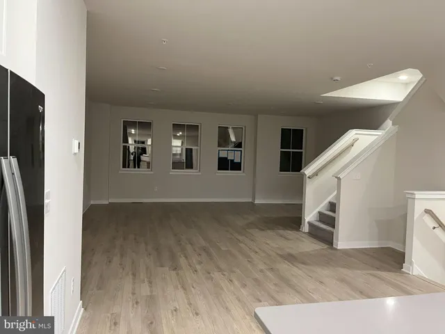 a view of a livingroom with wooden floor and stairs